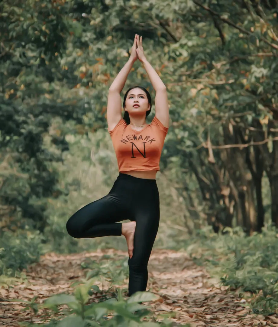 Woman in a tree pose on a forest path